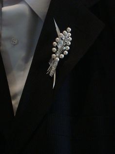 a man wearing a suit and tie with a boutonniere on his lapel