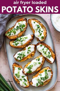 baked potato skins with sour cream and chives on a platter next to asparagus