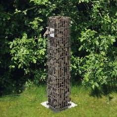 a tall wooden sculpture sitting in the middle of a lush green field