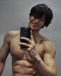 a shirtless man taking a selfie with his cell phone