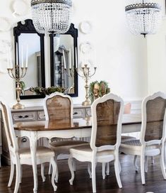 a dining room table and chairs with chandelier in the background on a hard wood floor