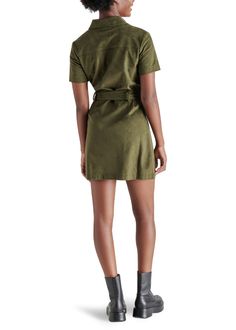 Experience the feel of luxurious faux suede in the Steve Madden Jolene Dress. This olive green mini dress features a tie at the waist, providing a sleek silhouette perfect for any occasion—from a girls night out to holiday festivities. Elevate your look with knee-high boots for a stylish fall look. Fit: True to Size Model is wearing a size S Imitation Leather: 100% Polyurethane Button closure all the way down If you would like to see more photos or speak with one of our stylists with any further Faux Suede Fabric, Leather Mini Dress, Loungewear Jumpsuit, Green Mini Dress, Plus Size Swimwear, Shirtdress, Fall Looks, Long Blouse, Sweatshirt Dress