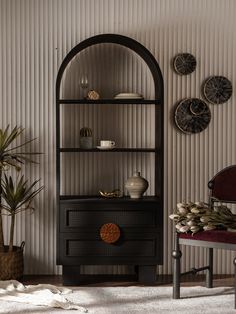 a living room with a chair, shelf and potted plant