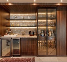 a bar with lots of bottles and glasses on the shelves in front of glass doors