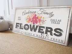 a sign that is sitting on the floor in front of a door with flowers painted on it