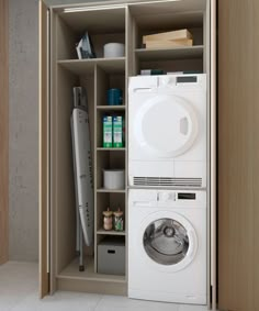 a white washer sitting inside of a wooden cabinet