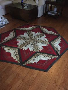 a red and white quilt on the floor in a living room