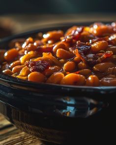 a bowl filled with cooked beans on top of a wooden table