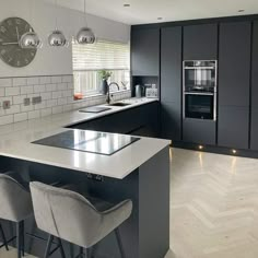 a modern kitchen with an island and bar stools