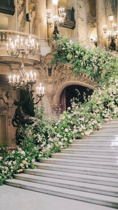 an ornate staircase with flowers and chandeliers on the side that says god is good