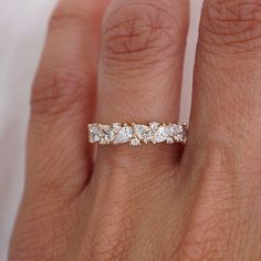 a woman's hand with a wedding ring on it and three stones in the middle