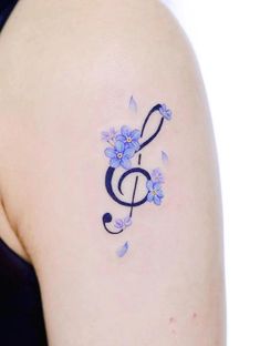 a tattoo with blue flowers and a treble