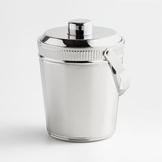 a white canister with a metal lid and a handle on the side, sitting in front of a white background