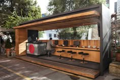 a man standing in front of a bar with stools on the side of it