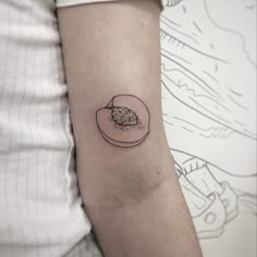 a small tattoo on the arm of a person with a piece of food in it