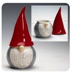 a gnome's hat is sitting on top of a small white and gray vase