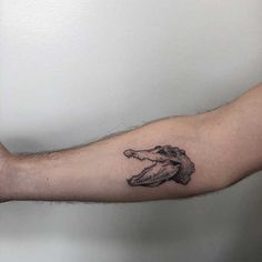 a man's arm with a tattoo of a hand holding an animal on it