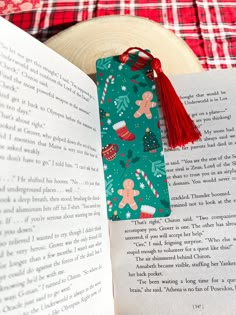 an open book with a red tassel on top of it next to a plate