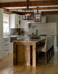 a large kitchen with an island in the middle and lots of lights hanging from the ceiling