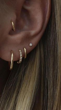 a woman wearing gold ear cuffs with diamonds