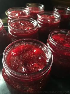 jars filled with red liquid sitting on top of a counter