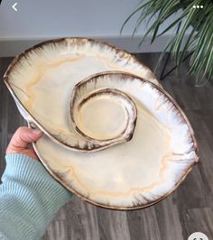 a person holding a white plate with a spiral design on it