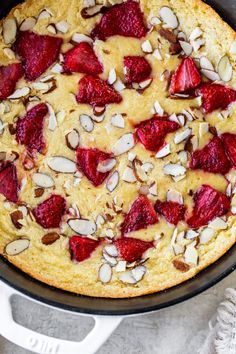 a cake with strawberries and almonds in a pan