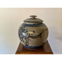 a blue and white vase sitting on top of a wooden stand