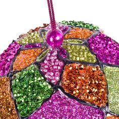 a colorful umbrella with lots of different colored beads on it's side and a pink candle sticking out of the top