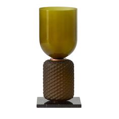 a brown vase sitting on top of a metal stand with a yellow glass in the middle