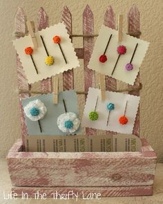 an old box is decorated with clothes pins and flowers