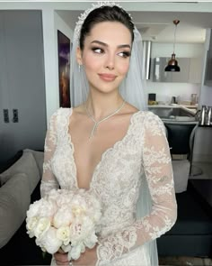 a woman in a wedding dress holding a bouquet and posing for the camera with her hands on her hips