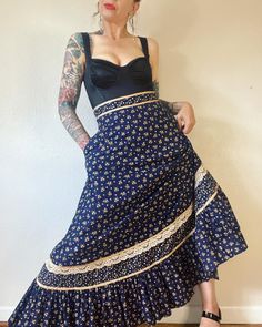 "Fall Floral. Beautiful Deadstock Vintage 1970's Gunne Sax, Jessica's Gunnies maxi skirt navy floral with side pocket's, champagne satin ribbon and lace trim and ruffle hem. THE perfect piece for Fall, except that it's too small for me..  Marked a vintage size 7 Fits XS (I'm about a M), but please use measurements as fit guide. 12.5\" waist (on the half)  22.5\" hip (on the half)  43\" length  Unlined  Center back zipper and double button closure  Cotton  Side pockets  Full skirt  Stain trim at waist and hem  Lace trim at hem Ruffle hem  Excellent vintage condition" Stained Trim, Ribbon Skirt, Masc Outfits, Skirt Details, Gunne Sax, Womens Skirts, Fall Floral, Navy Floral, Vintage Skirt