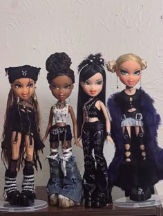 five dolls are lined up next to each other on a shelf in front of a white wall