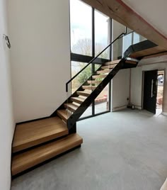 an empty room with stairs leading up to the second floor