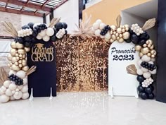 two black and white balloons are on display in front of a gold sequin backdrop