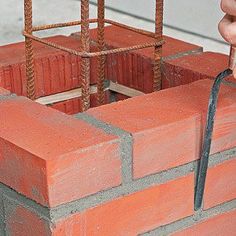 a brick wall being worked on by a hand