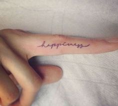 a person's hand with the word happiness written on it, in cursive handwriting