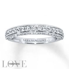 a white gold wedding band with round cut diamonds on the top and side, set in 18k white gold