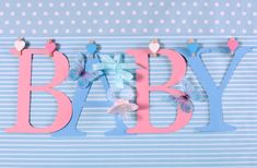 the word baby spelled out in pink, blue and white paper with butterflies on it