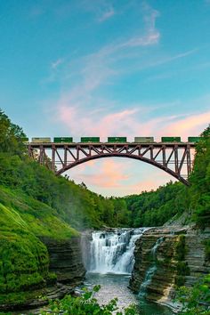 a bridge over a waterfall with a train on it