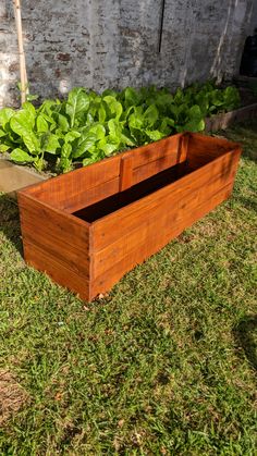 a wooden planter sitting on top of a lush green field