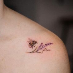 a woman's chest with a bee and lavender tattoo on it