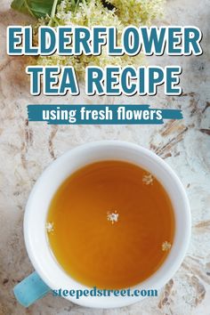 elderflower tea recipe using fresh flowers in a white cup on a marble surface with text overlay