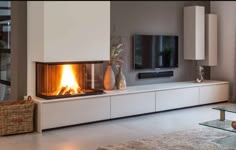 a living room with a fire place in the center and a television on top of it