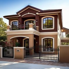 a brown and white house with black iron fence