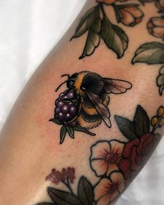 a tattoo with a bee and flowers on it