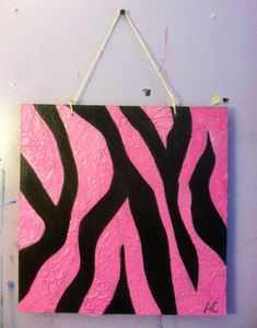 a pink and black zebra print hanging on a purple wall with white string attached to it