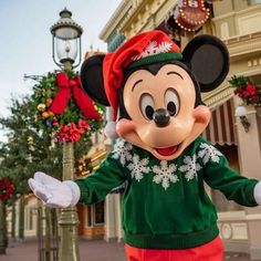 the mickey mouse character is dressed in green and red for christmas at disney's hollywood studios