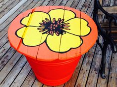 an orange and yellow flower painted on top of a wooden table